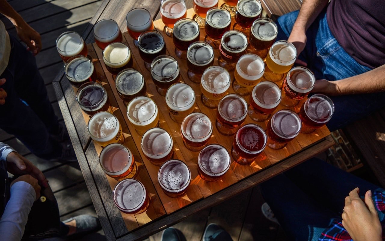 Symbolbild Brauereiführung/Bierverkostung: Gruppe probiert viele verschiedene Biersorten an einem Tisch