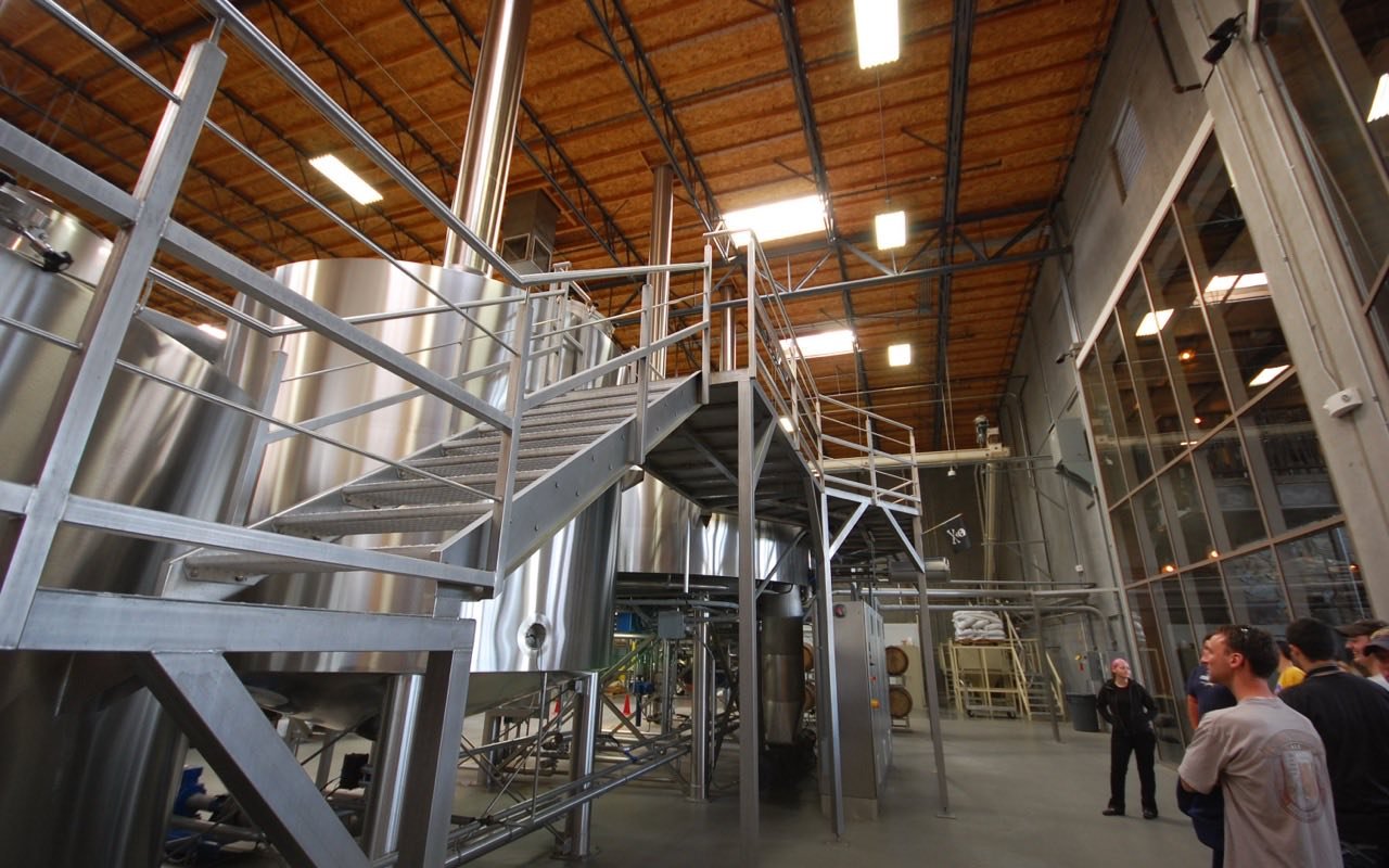 Symbolbild Brauhaus mit Gruppenraum: Brauereihalle mit Tanks und Treppen