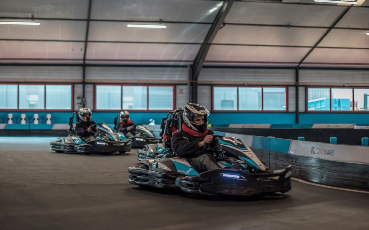 Symbolbild Eventlounge an Kartbahn: Mehrere Fahrer beim Rennen auf einer Indoor Kartbahn