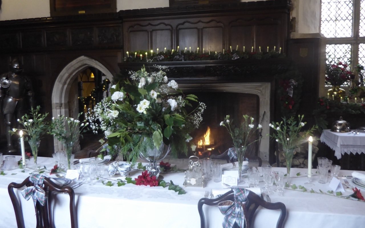 Symbolbild Kleine Eventlocation: Festlich gedeckte Tafel mit Blumen in einem historischen Saal
