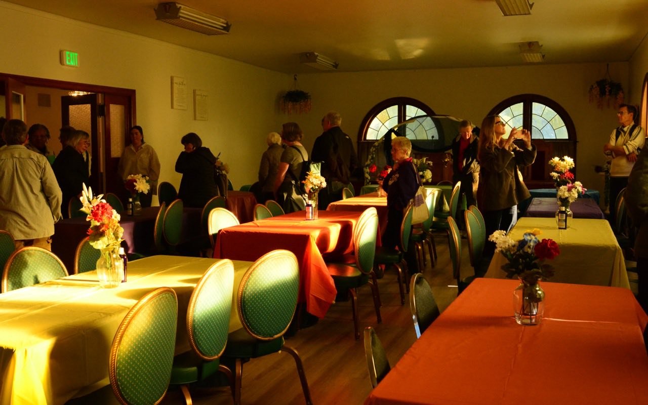 Symbolbild Kleine Eventlocation: Bunter Festsaal mit Tischen und Blumen