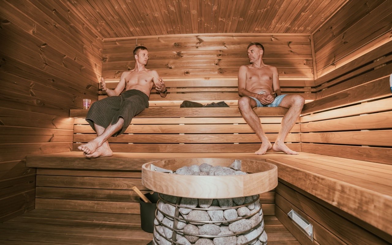 Symbolbild Sauna/Therme: Zwei Männer entspannen in einer warmen Holzsauna
